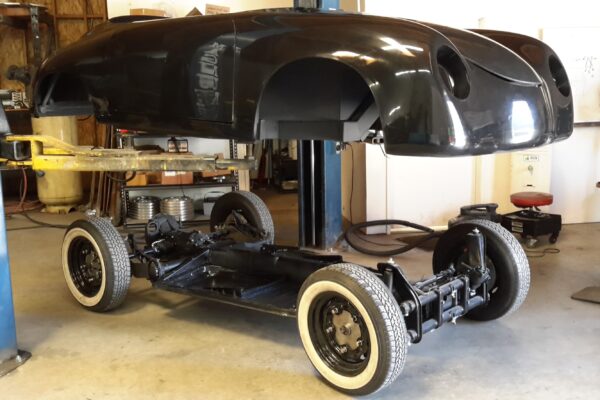 Car chassis on a lift in a garage setting